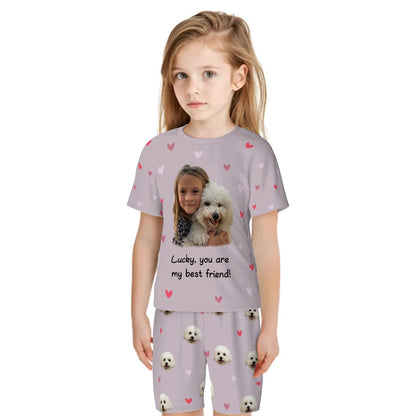 Bespoke kids pajama set with an all-over print featuring an example scene of a child and their dog, saying "Lucky [which is the dog's name], you are my best friend!" We transform your photos into a unique, custom-colored design for the proud parent.
