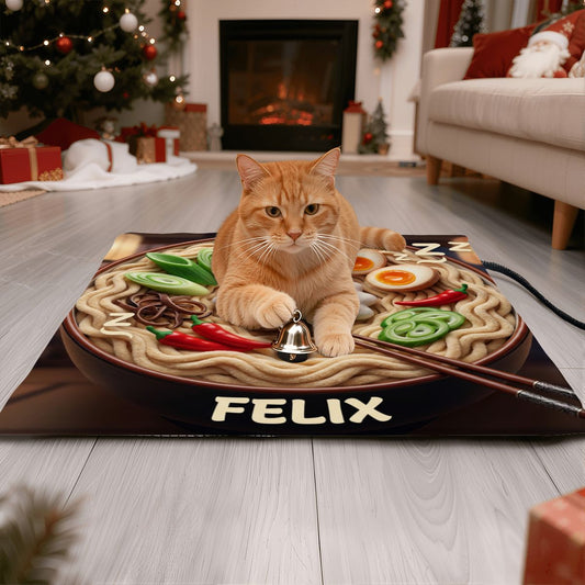 Bespoke pet heating pad featuring an example ramen bowl scene with the name 'Felix' and an orange tabby cat laying on top, holding a bell, ready to ask for his meal. We design unique, meaningful scenes for your non-human family to enjoy.